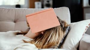 woman lying on the couch with a book covering her face