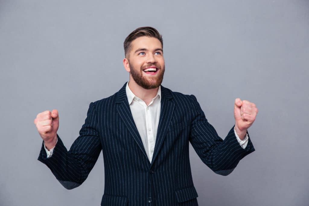 cheerful loan officer celebrating his success in a button up shirt and suit jacket