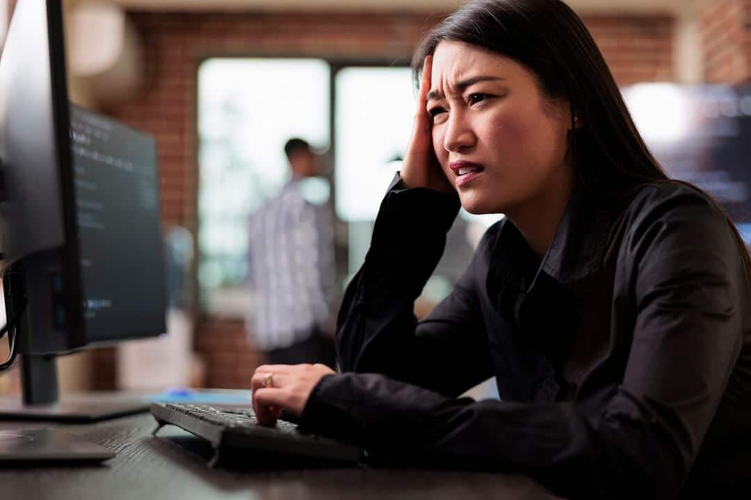 Confused mortgage officer sitting in front of computer