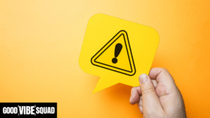 hand holding a yellow warning sign against a yellow background